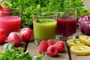 Two glasses of juice, some raspberries and other bits of fruit