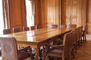 a wood panelled room with a large wooden table and leather chairs