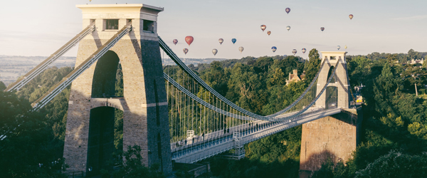 Bristol suspension bridge with several colourful hot air balloons flying over it
