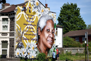 a large end mural on a house featuring a black woman and yellow flowers