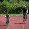 A boy and a man cycling on an outside cycle track.