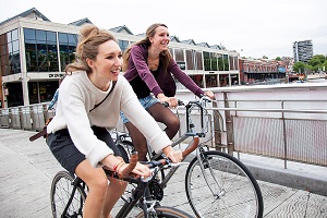 Photograph of two women cycling across a bridge in Bristol.
