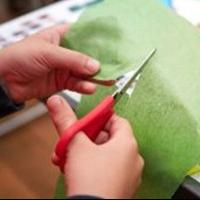 Someone cutting colourful tissue paper.