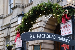 Entrance to St Nicholas Market decorated with a festive garland and lights