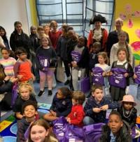 A group of children holding prizes in a library