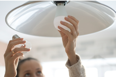 Someone replacing a light bulb.