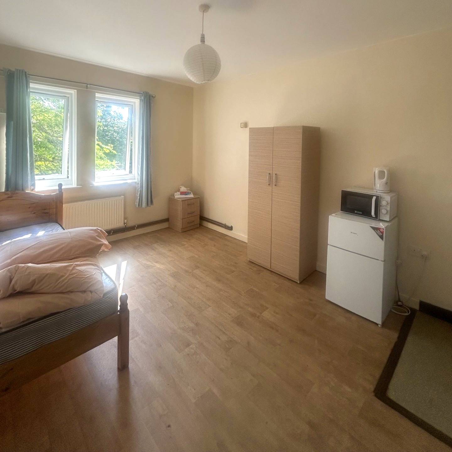 Bedroom with bed, wardrobe, fridge, microwave and kettle