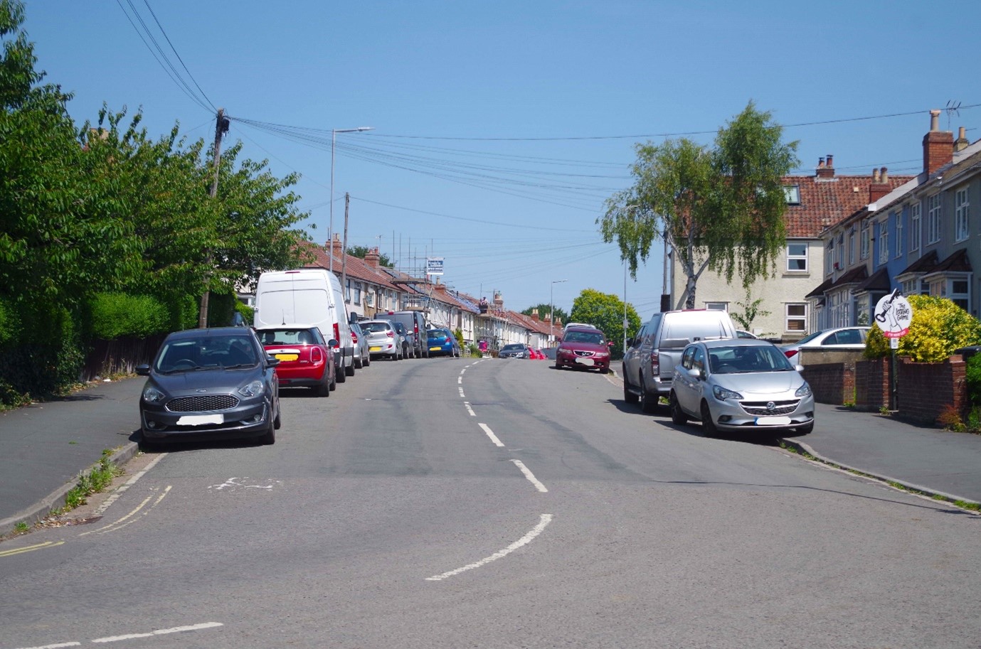 Photograph of Dovercourt Road looking north from the junction with Downend Road, showing parking on both sides of the road, some parked partly on the pavement