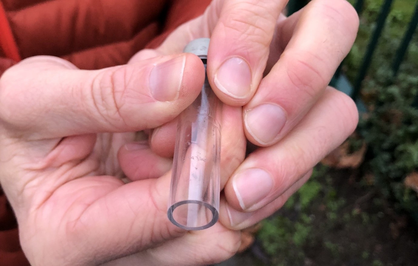 Person holding an air quality monitoring tube in their hands