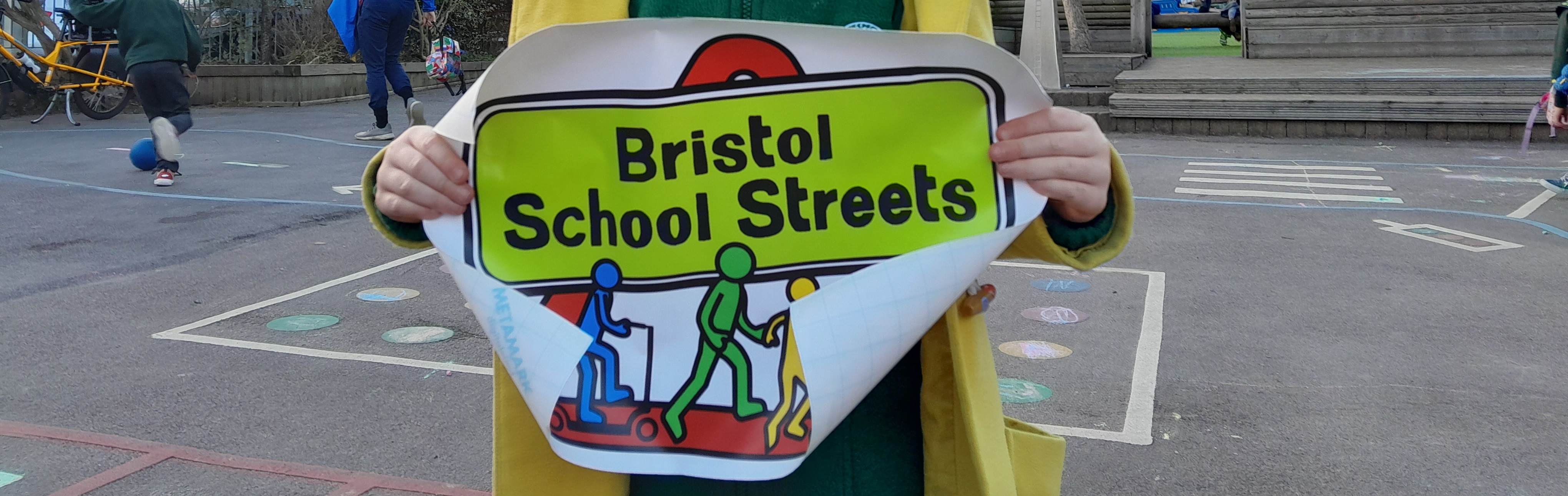 Child holding a Bristol School Streets sign