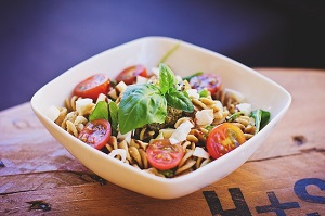 A pasta dish with tomatoes and basil leaves