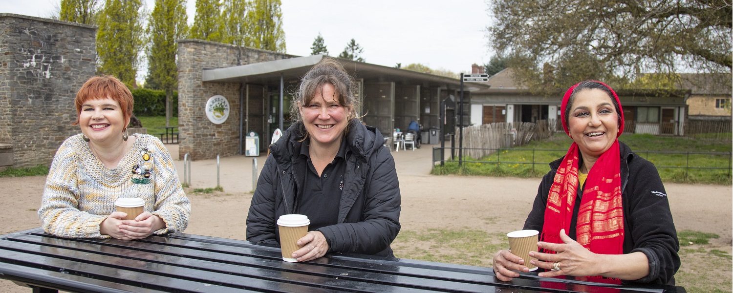 Three women enjoying hot drinks outside Blaise Estate Cafe