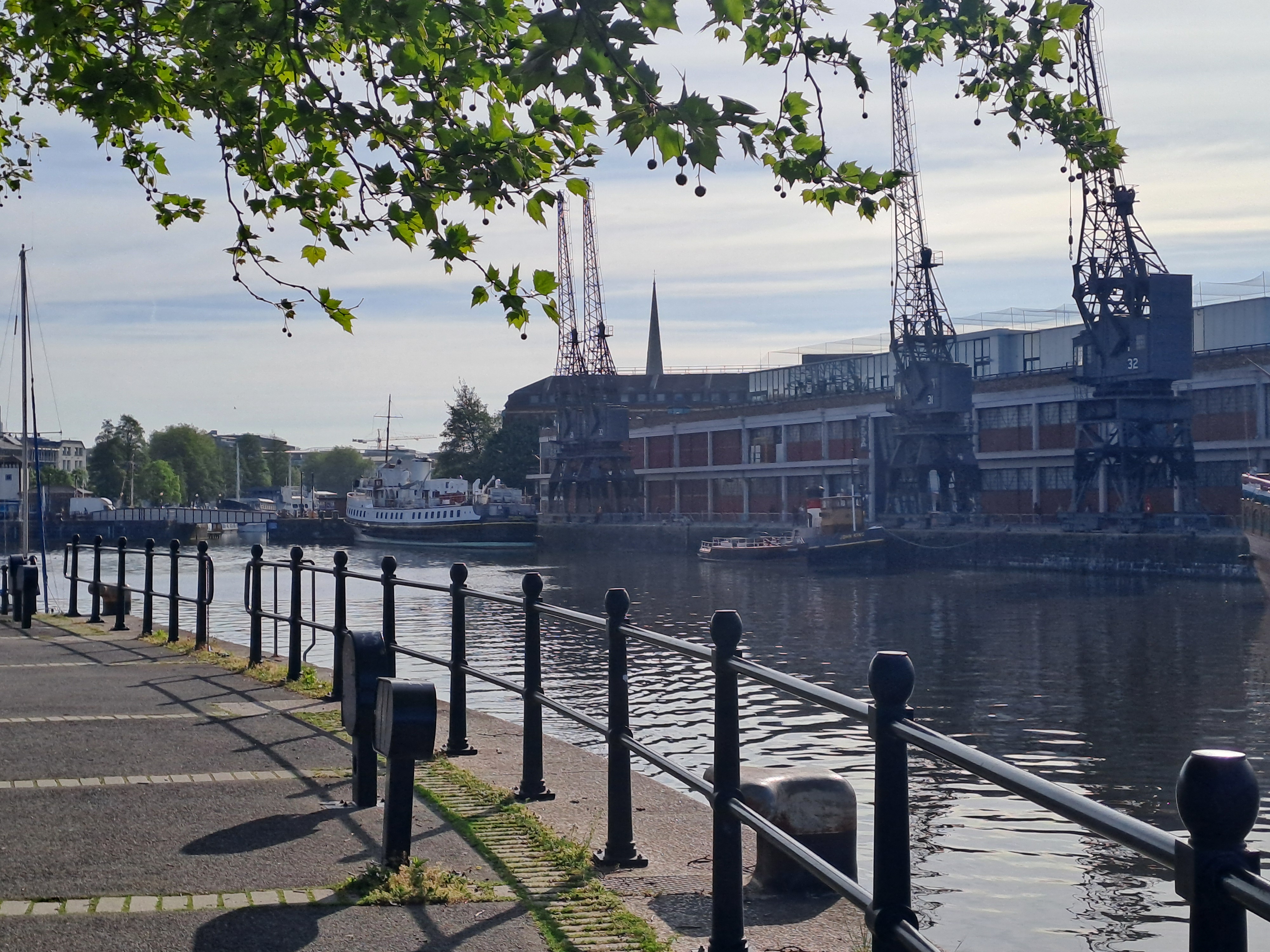The railings at the side of the water, the M Shed and the cranes in the background