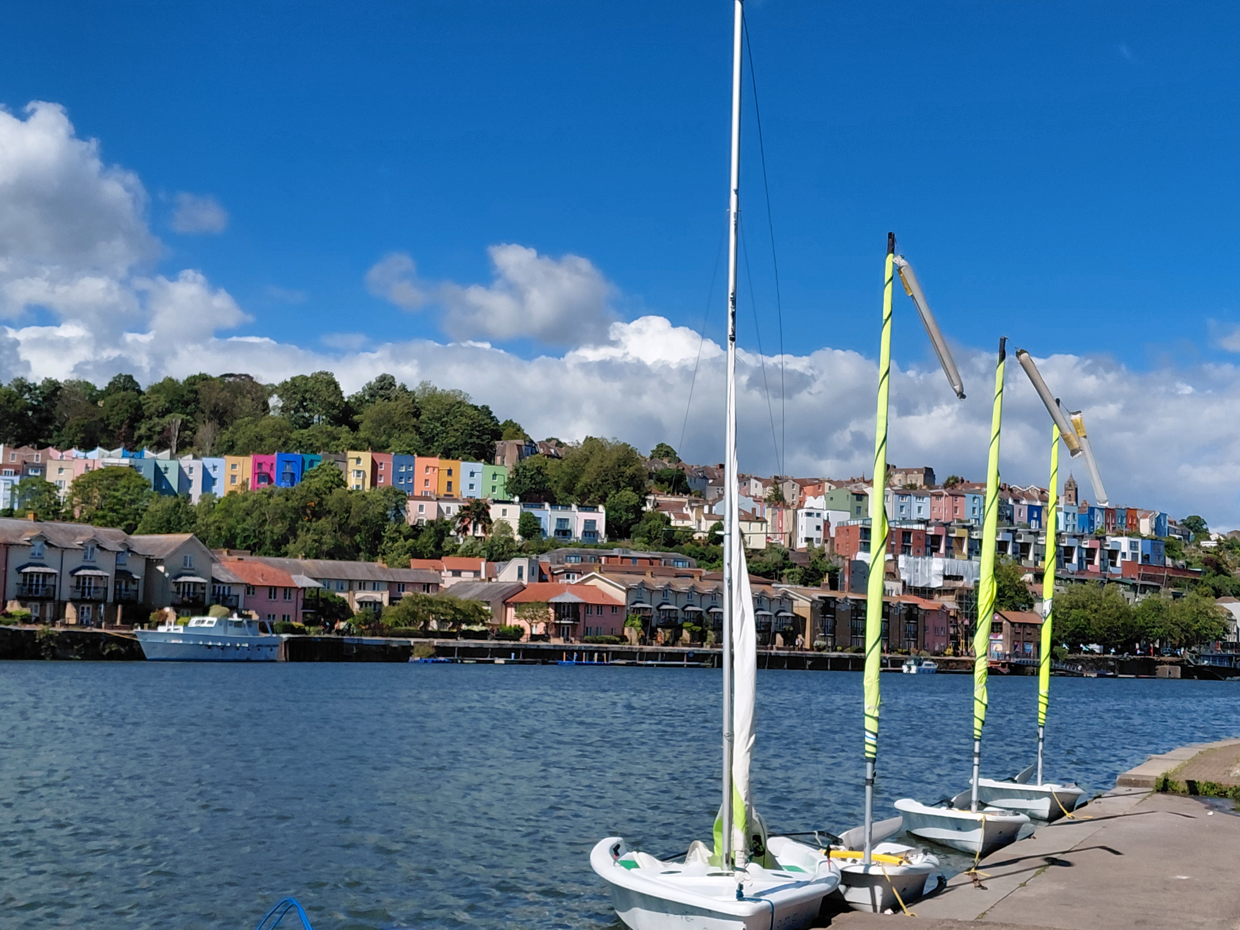A view of the harbour with some boats to the right and the view of some colourful houses to the left 