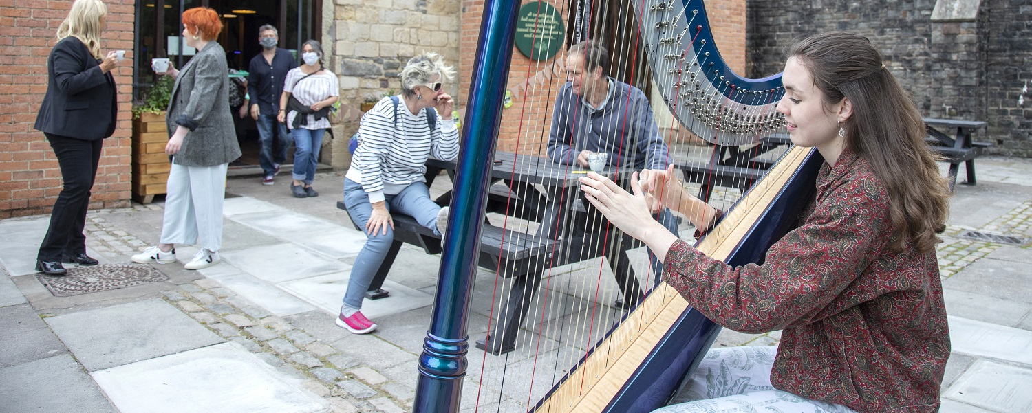 A harpist playing outside the cafe