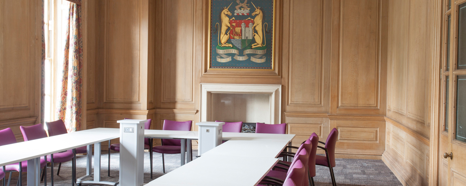 a wood panelled meeting room in city hall with the bristol crest on the far wall