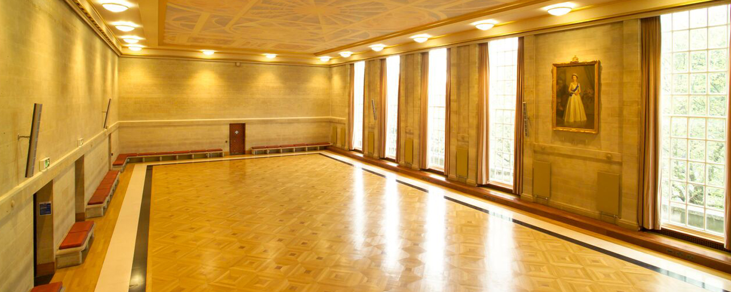 A large room with painted ceilings and high windows flooded in light