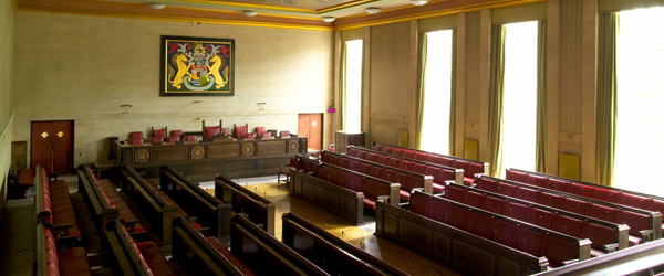 a large room with leather pews and a large bristol crest on the wall