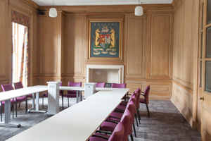 a wood panelled room in city hall with the bristol crest on the far wall