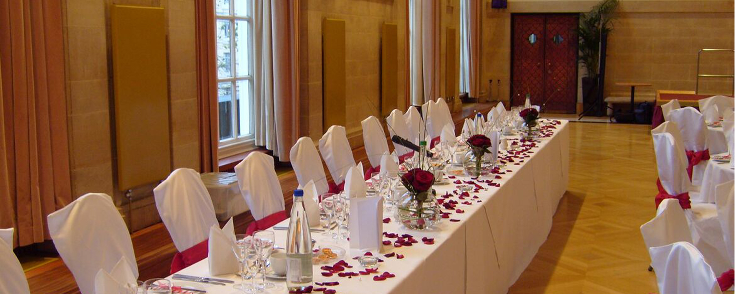 A long table with white tablecloth set for a wedding reception in City Hall