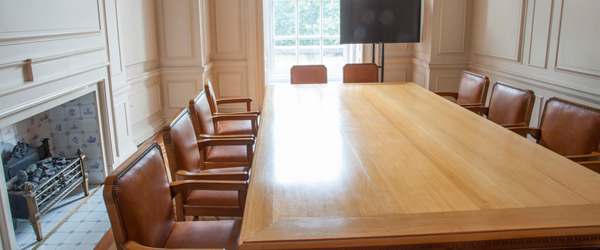 a heritage room with a rectangular wooden table and leather chairs