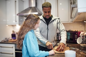 A young man and teenage girl cooking