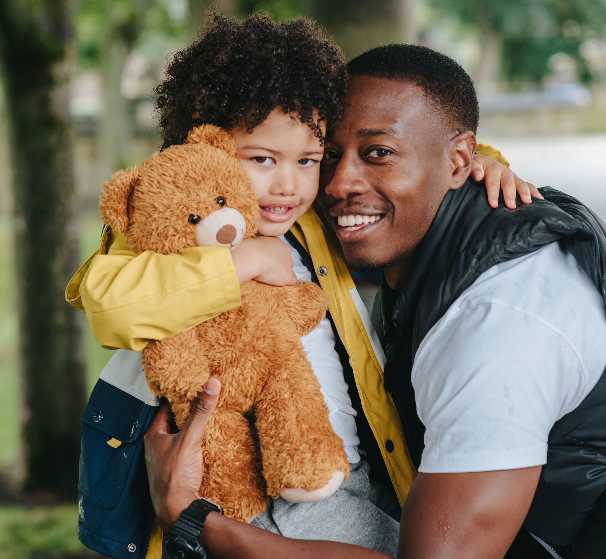 Man and small child holding a teddy