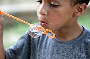 A young boy blowing bubbles