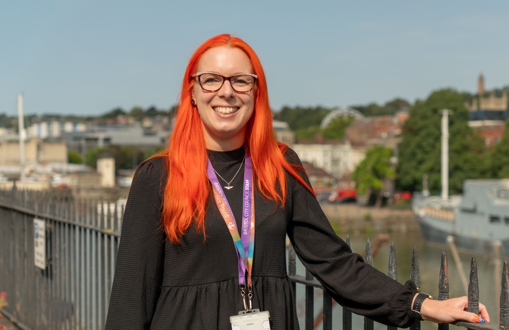 Woman smiling while standing in front of a fence