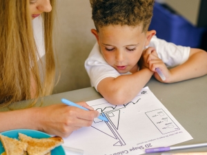 Young boy with his caregiver doing homework