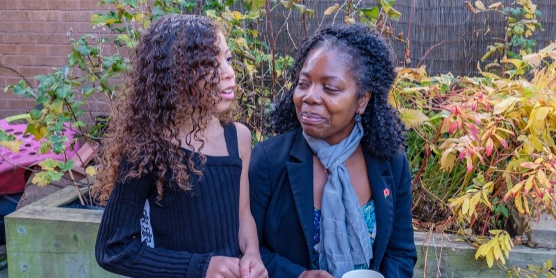 Carer and girl in garden resized cropped