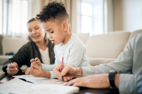 Older carers with a boy helping him do homework