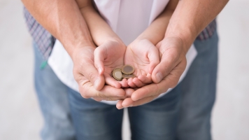 Dad and daughter holding coins in their hands