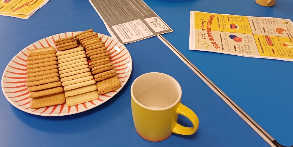 Tea and biscuits on a table with support group leaflets