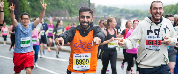 a group of marathon runners running towards the camera and smiling