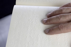 A hand on a page of Braille