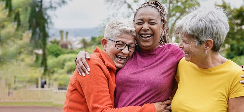 3 ladies hugging and smiling. 