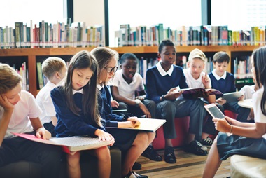 A classroom full of young people reading.