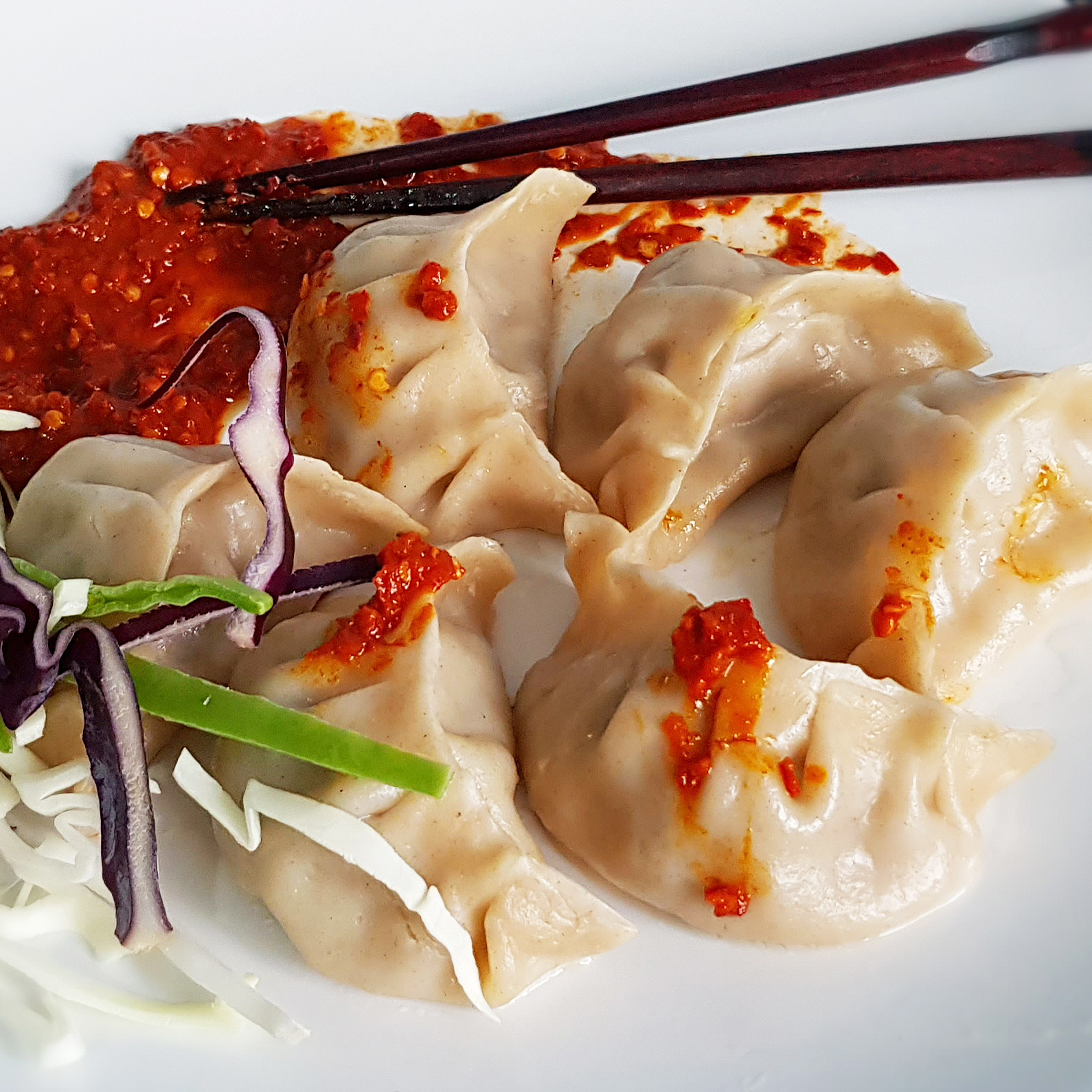 Close up of momo Tibetan dumplings with chilli sauce.