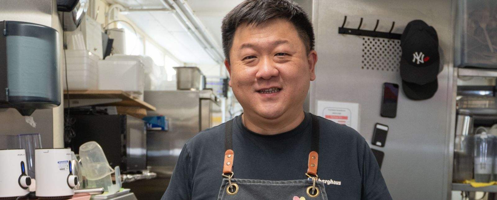 A man in an apron standing in a kitchen