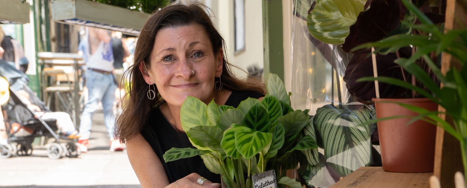 A woman crouching next to some plants 