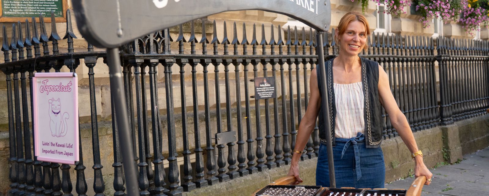 A market seller holding a cart containing jewellery