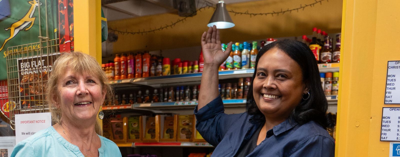 Two female shop owners posing outside their shop 