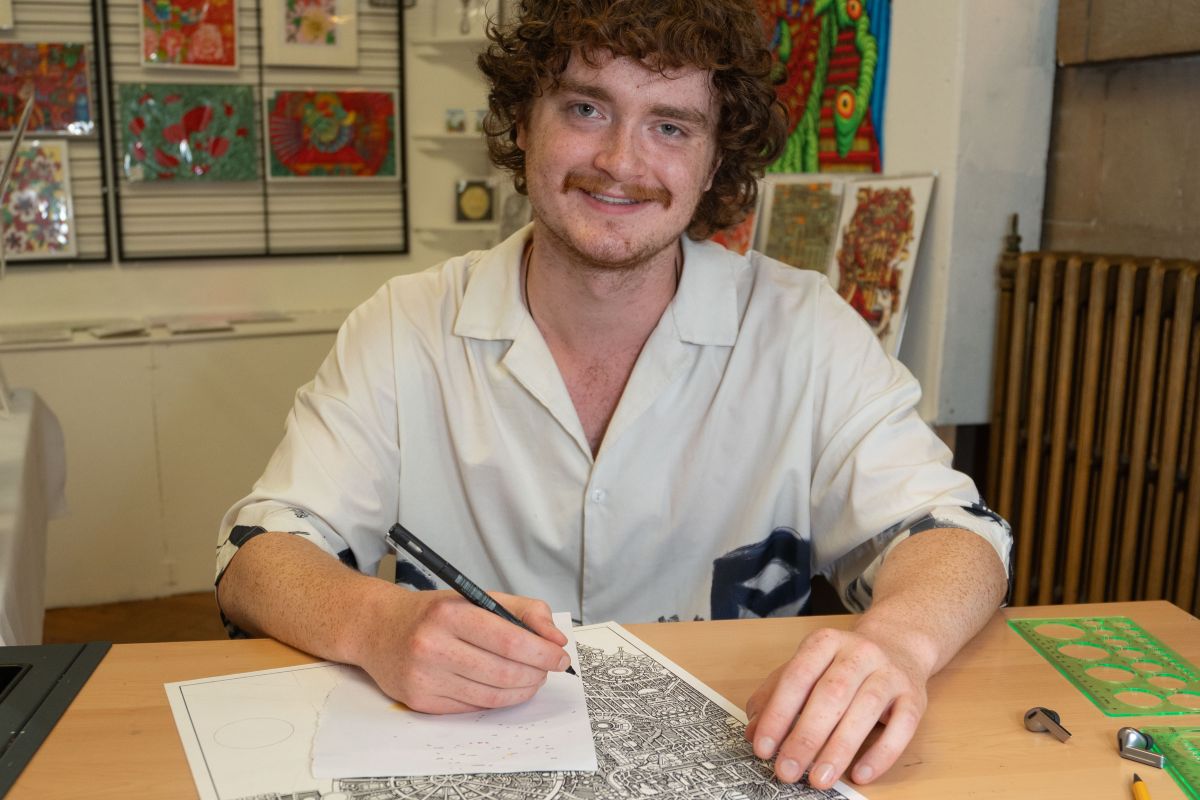 A man who is drawing smiling
