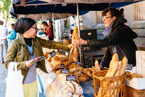 A lady buying bread from a market