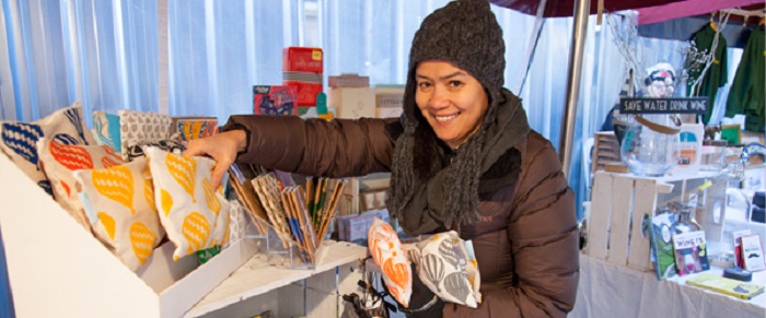 A woman selling cushions on a market stall