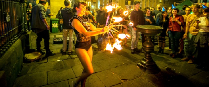 A woman juggling firesticks 