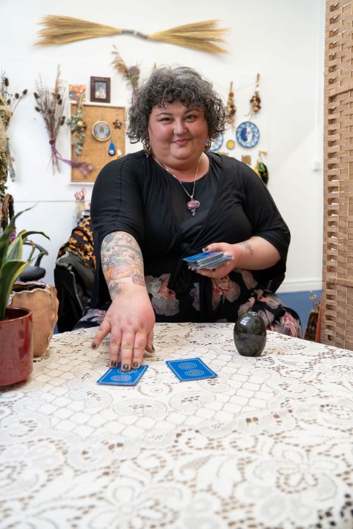 A woman placing tarot cards face down on a table