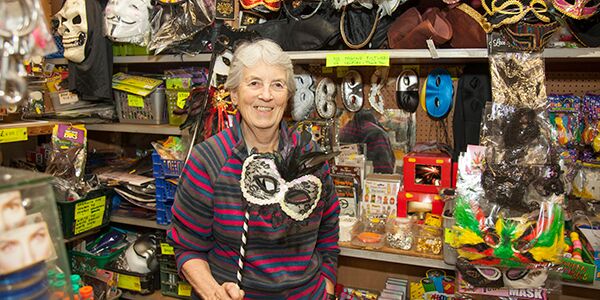 A lady holding a mask in a shop