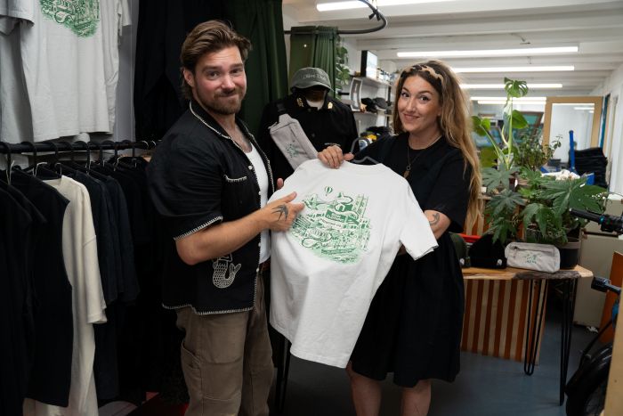 Two people holding up a t-shirt, smiling